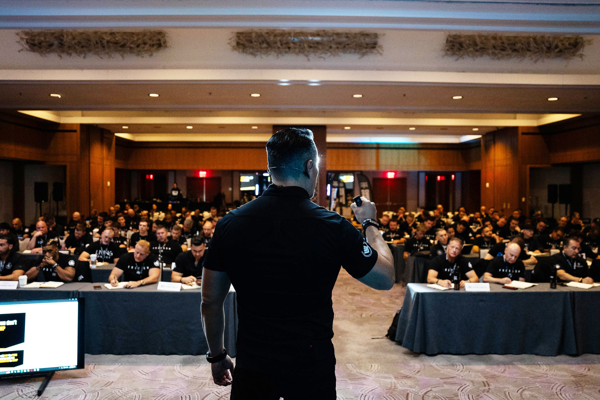 Raul Villacis speaking passionately on stage during a live EDGE leadership summit event, coaching high-performing men on overcoming pressure.